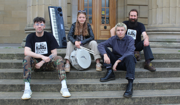The Observers at Dundee's Caird Hall Dundee band The Observers sitting on steps outside The Caird Hall