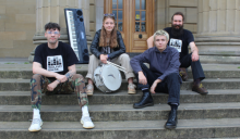 Dundee band The Observers sitting on steps outside The Caird Hall